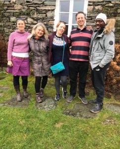 Five people standing in a line smiling