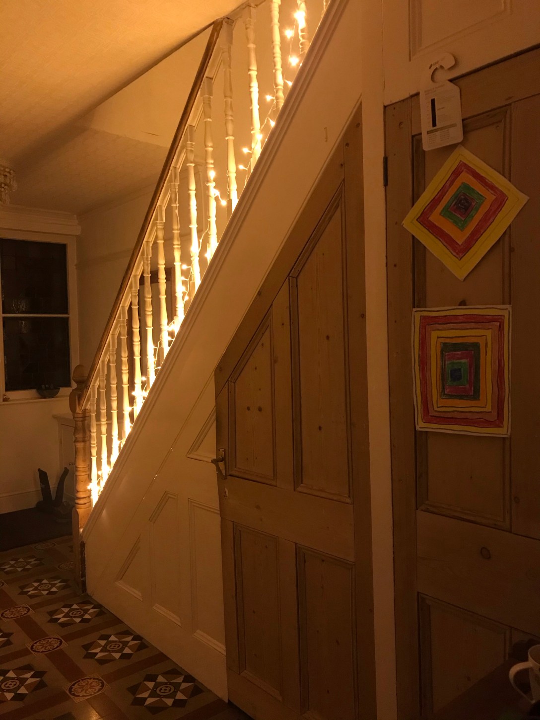 a picture of the side of a staircase, lit by fairylights