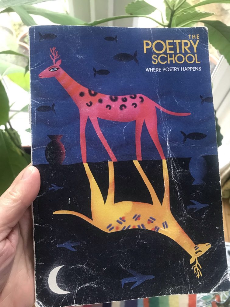 The image is of a white hand holding a small notebook.