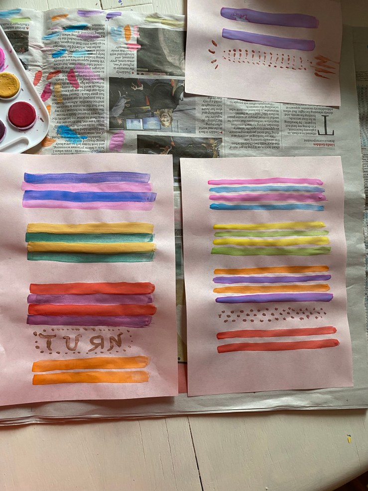 Two pieces of pink paper, side by side, which are coloured in stripes of paint, with each stripe representing a line from a sonnet.