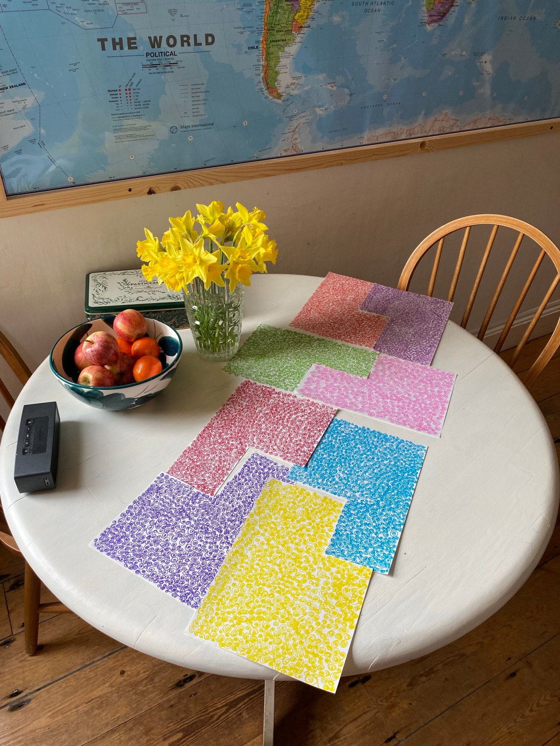 paper variously coloured with swirling patterns laid out on a small round dining table
