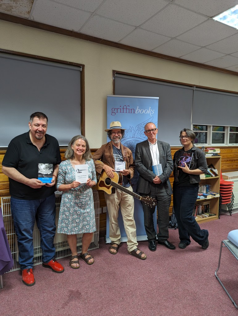 A line of performers holding up their books