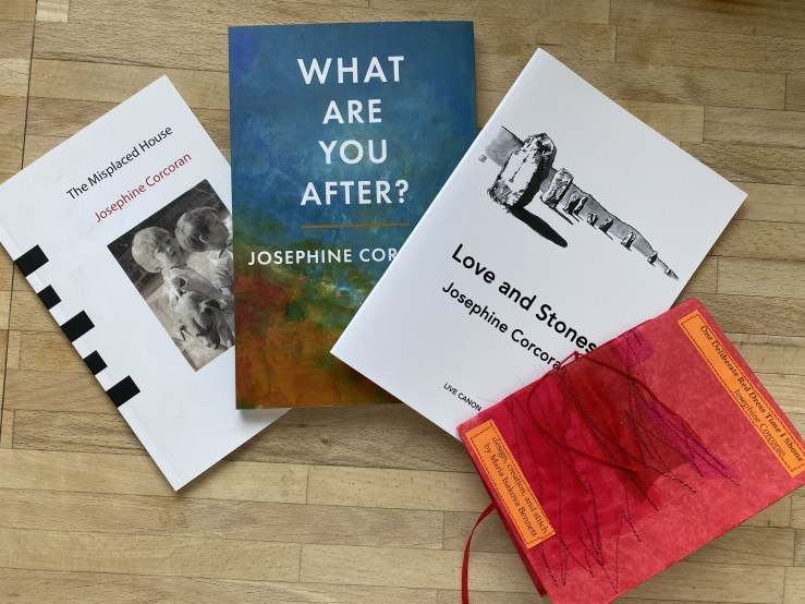Four books by Josephine Corcoran arranged in a fan-like line. The books are The Misplaced House, What Are You After?, Love and Stones, One Deliberate Red Dress Time I Shone.