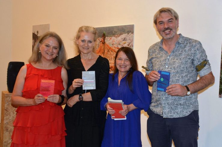 Josephine Corcoran, Rachel Spence, Maria Isakova Bennett and Ben McGuire standing in a row holding their handstitched poetry journals.