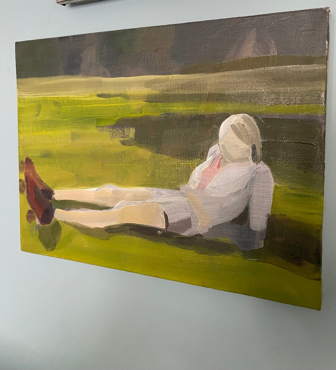A painting by Philippa Sutherland of a female figure in rollerskates, with legs outstretched, reclining on grass.